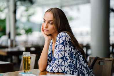 woman in white and blue top sitting in front table