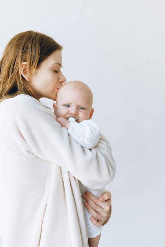 woman in white robe carrying baby